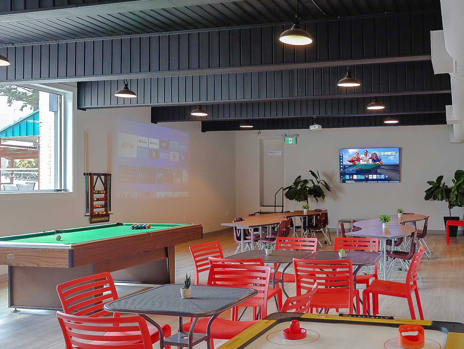 The rec room at Scott's Inn; red, funky chairs, a pool table, an air hockey table, a flat-screen TV on the wall.
